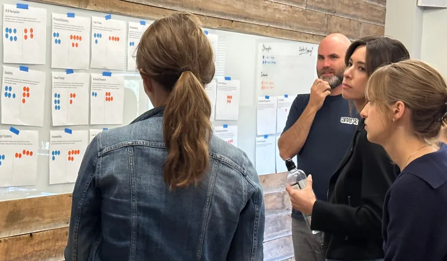 Group of professionals conversing in front of a whiteboard